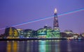 London, England - Laser light across the night sky of London with Shard skyscraper