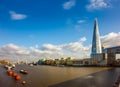 London, England - London`s highest skyscraper with the iconic Tower Bridge at background on a sunny afternoon