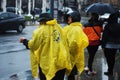 LONDON, ENGLAND-March 11, 2018 - Two womn in rain coat, under the rain waiting for buses in the morning. Street view. Royalty Free Stock Photo