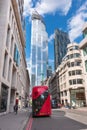 London, England - May 12, 2019: London`s iconic red double-decker bus with awesome modern skyscrapers architecture in