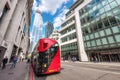 London, England - May 12, 2019: London`s iconic red double-decker bus with awesome modern skyscrapers architecture in