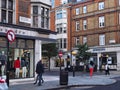 Pedestrians walk past fashion retailers on the main street in the Marylebone district