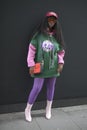 Beautiful and stylish Girl in a green sweatshirt with pink sleeves and purple leggings. during the London Fashion Week. outside Eu