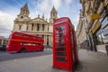 London, England - Traditional red telephone box with iconic red vintage double-decker bus on the move