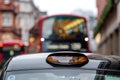 London, England, UK - December 31, 2019:  A british london black taxi cab sign with defocused  red bus in background Royalty Free Stock Photo