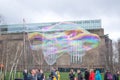 London, England, United Kingdom - March 15, 2020 - People entertained by man with giant bubbles outside Tate Modern Gallery on the Royalty Free Stock Photo