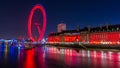 London Eye ferris wheel colored red at night with the river Thames in London England Royalty Free Stock Photo