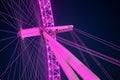 The London Eye illuminated pink against a deep blue night sky