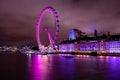 London Eye illuminated in purple at night with River Thames and County Hall in the background Royalty Free Stock Photo