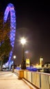 Portrait view of Houses of Parliament, Big Ben and the London Eye at night from the South Bank