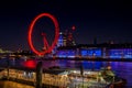 London Eye observation wheel and city lights by the River Thames in London at night