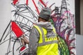 London, January 26, 2020. Professional painter at work, painting a street wall.Young man painting the wall, street art in process