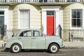 London - March 30: Oldtimer car parked in front of Kensington luxury town house on March 30, 2017