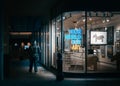 London - 08 March 2020 - Street Photography of Man Walking next to Gallery Window with Neon at Night, London UK Royalty Free Stock Photo