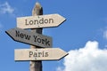 London, New York, Paris - wooden signpost with three arrows