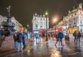 London - October 2019: tourists by the statue of Anteros at Piccadilly Circus at night after rain