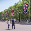 London policeman give information to asian tourist at the Guard Changing parade at Buckingham Palace in London, UK