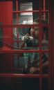 In a London red telephone booth, a child boy is holding a phone while talking to his mother. Rebeok calls home from an Royalty Free Stock Photo