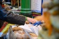 A customer paying for loaves of bread at a bread stall in Borough Market, London