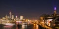 London Skyline at Night with Thames River, Bridges, City Buildings and Riverboats Crossing Royalty Free Stock Photo