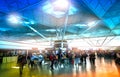LONDON STANSTED AIRPORT, UK - MARCH 23, 2014: Passengers in the airport departure aria, waiting by the information desk, looking Royalty Free Stock Photo
