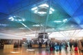 LONDON STANSTED AIRPORT, UK - MARCH 23, 2014: Passengers in the airport departure aria, waiting by the information desk, looking Royalty Free Stock Photo