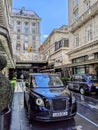 London taxi in front of a luxurious hotel