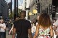 London, U.K., August 22, 2019 - cheerful young afro american couple walking on urban street in london.