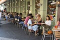 London, U.K., August 22, 2019 - Families and friends from different cultures talk, eat and drink at outdoor cafe terrace
