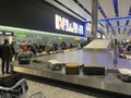 People collecting and searching for their luggage in an airport baggage area.