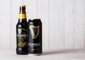 LONDON, UK - APRIL 27, 2018: Bottle and aluminium can of Guinness draught stout beer bottle on light wooden background.