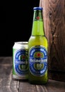 LONDON, UK - APRIL 27, 2018: Bottle and aluminium can of Heineken Alcohol free Lager Beer next to wooden barrel