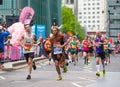 Happy Marathon runner in funny costume cheering by public. Charity money raise. London, UK