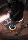 LONDON, UK - APRIL 27, 2018: Original glass of Guinness draught stout beer on top of old wooden barrel with beer coaster and opene Royalty Free Stock Photo