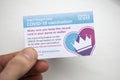 LONDON, UK - APRIL 2021. A person holding NHS Covid-19 vaccination record card Royalty Free Stock Photo