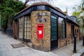 LONDON, UK - April, 13: Red postbox with tiled street sign, London