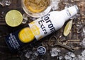 LONDON, UK - APRIL 27, 2018: Steel Bottle of Corona Extra Beer on wooden background with bottle opener and ice cubes and glass of Royalty Free Stock Photo
