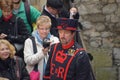 London, UK - April 2015 : Yeoman of the Guard in uniform  gives a guided tour of the Tower of London to tourists holding cameras Royalty Free Stock Photo