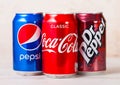 LONDON, UK - AUGUST 03, 2018: Aluminium cans of Coca cola and Pepsi and Dr.Pepper soft drink on wooden background.American