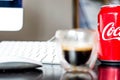 Can of Coca cola and an Esspresso Coffee on a Desk