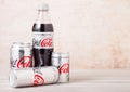 LONDON, UK - AUGUST 03, 2018: Plastic bottle and aluminium tins of Diet Coke Coca Cola soft drink on wooden background. Most