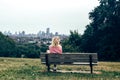 Blonde woman sitting alone on a bench Royalty Free Stock Photo