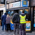 Group Of People Customers Queuing Outside Greggs Bakery For Takeaway Food