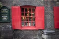 Window with red shutters, decorated with a drawing with a horse in a traditional Christmas