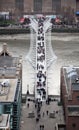 London Millennium foot bridge over the River Thames and office people walking through Royalty Free Stock Photo