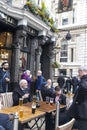 Elderly men and women communicate with each other while sitting at the tables near the pub The Red