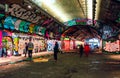 London, UK/Europe; 21/12/2019: Leake Street, underground tunnel with graffiti covered walls in London. Scene with pedestrians and Royalty Free Stock Photo