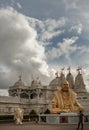 Exterior view of the Neasden temple (BAPS Shri Swaminarayan Mandir) and The gold colored statue