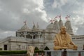Exterior view of the Neasden temple (BAPS Shri Swaminarayan Mandir) and The gold colored statue depicts.