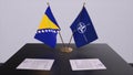 London, UK - 15 February 2023: Bosnia and Herzegovina country national flag and NATO flag. Politics and diplomacy